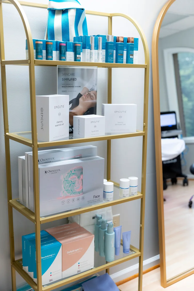 A gold shelving unit holding Colorescience, Epicutis, Omnilux and PRX products