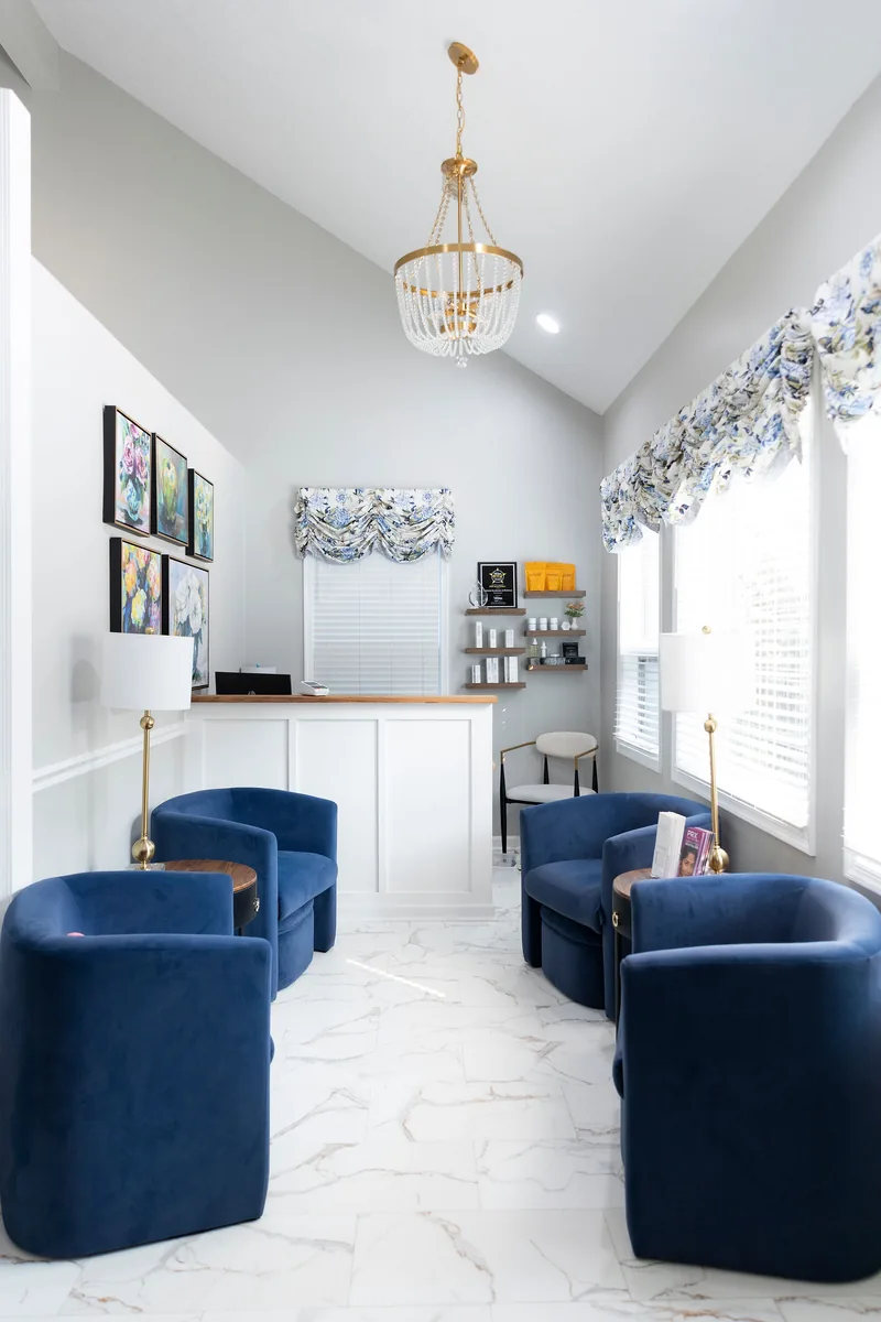 The Colonial Aesthetics waiting room — navy velvet chairs, a beaded chandelier and the reception desk